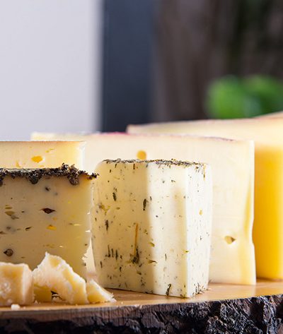 Ein Holzbrett mit verschiedenen angeschnittenen Käsetückchen
