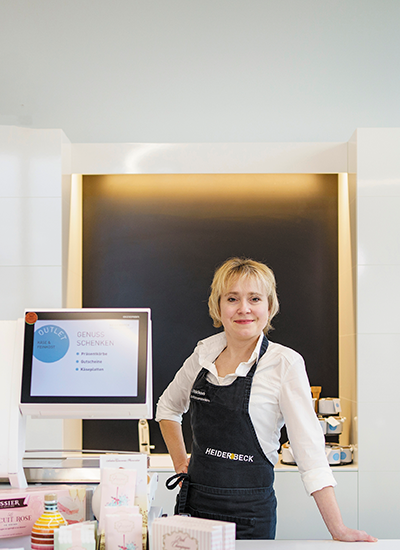 Anna Maidic posiert an der Outlet Kasse im Heiderbeck Feinkost Outlet