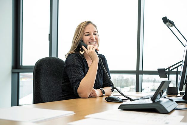 Mitarbeiterin Sabrina telefoniert am Arbeitsplatz