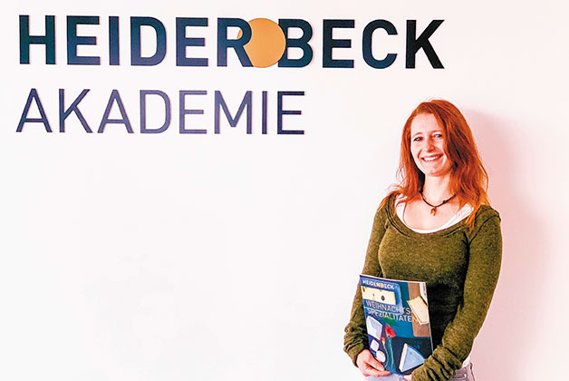 Bild von Nadja Thoma mit einem Weihnachtskatalog in der Hand vor der Heiderbeck Akademie