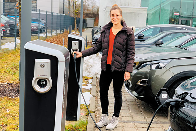 Sabrina tankt an einer E-Zapfsäule Strom für ein E-Auto