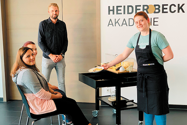 Franziska Schröter trainiert den Verkauf am Käsewagen mit Trainer Andreas Albrecht und zwei Mitschülerinnen