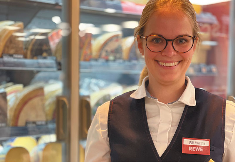 Bild von der Diplom Käsesommeliere Laura Lenk vor einem Käsekühlschrank