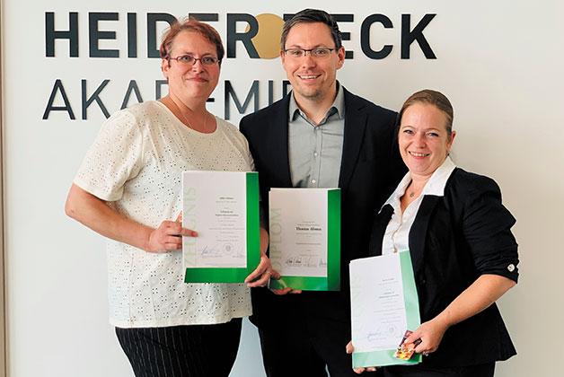 Thomas, Yvonne und Nicole posieren mit ihrem Diplom zum Kässommelier vor der Heiderbeck Akademie