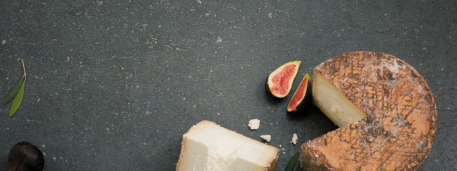 Ein angeschnittener Laib Roccolo Käse auf dunklem Hintergrund