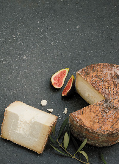 in angeschnittener Laib Roccolo Käse auf dunklem Hintergrund