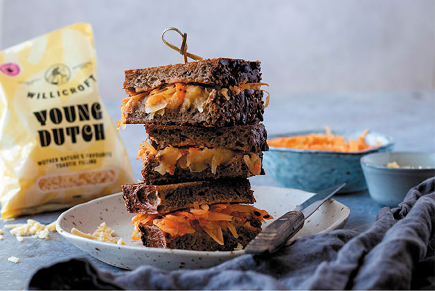 Ein Käsetoastsandwich mit blauen Töpfen im Hintergrund und einer Packung Young Dutsch, einem veganen Käse