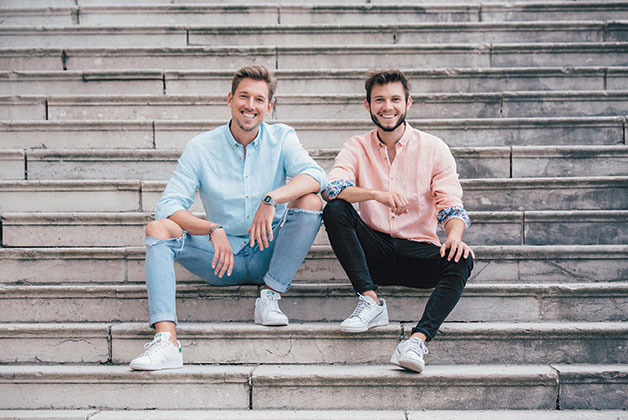 Die beiden Gründer von Happy Ocean sitzen zusammen auf einer Treppe