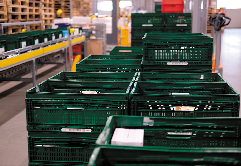 Bild einer Palette mit grünen Mehrwegkisten, die mit Käse gefüllt sind, im Heiderbeck Lager